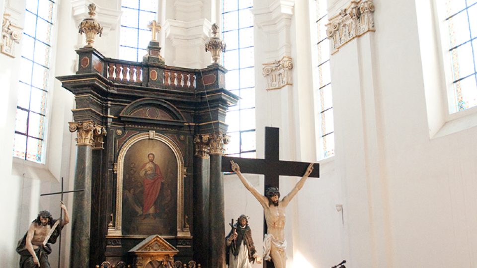 Zvědavé pohledy archeologů do malého otvoru v podlaze.